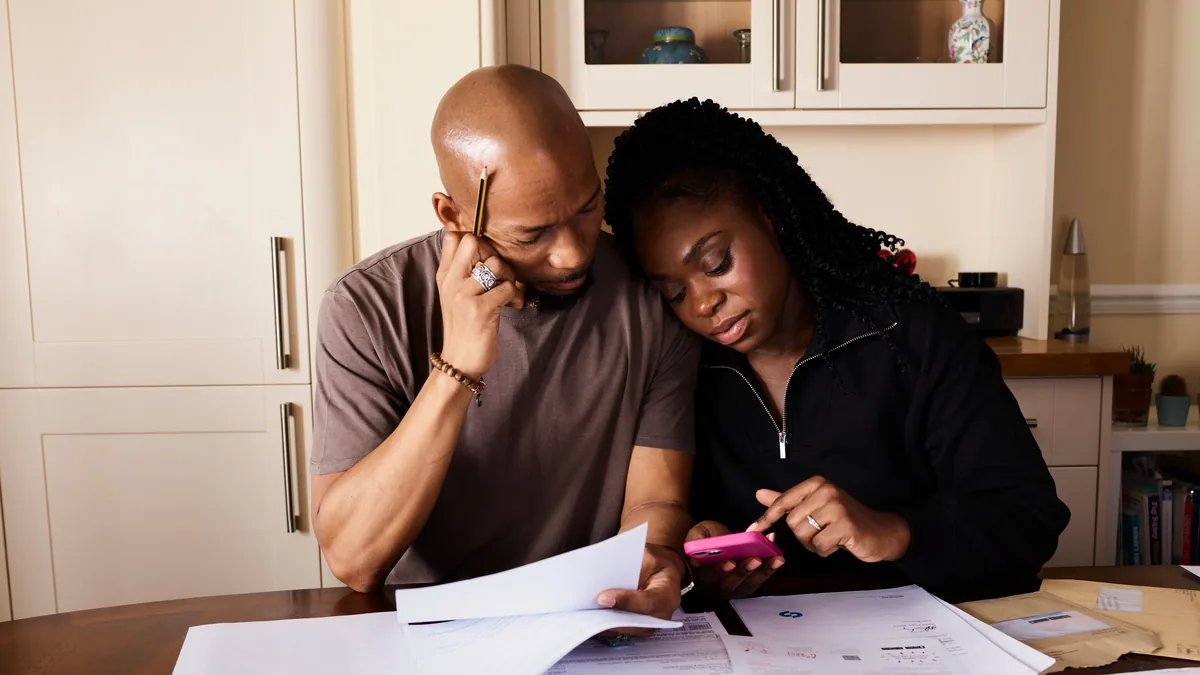 Couple reviewing bills and statements working to improve credit score