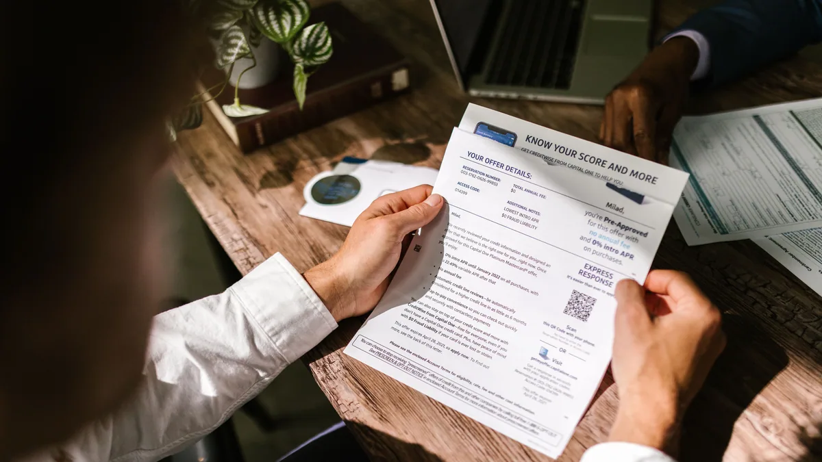 Person reading credit card pre-approval offer letter from OneMain Financial